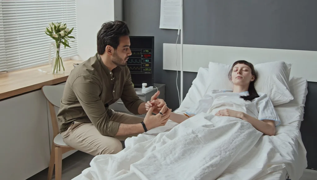 Man holding hands with a coma patient